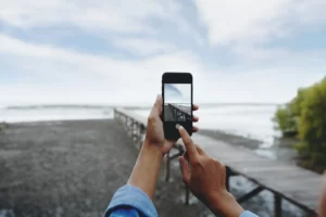 A person takes please a landscape photograph with an iPhone.
