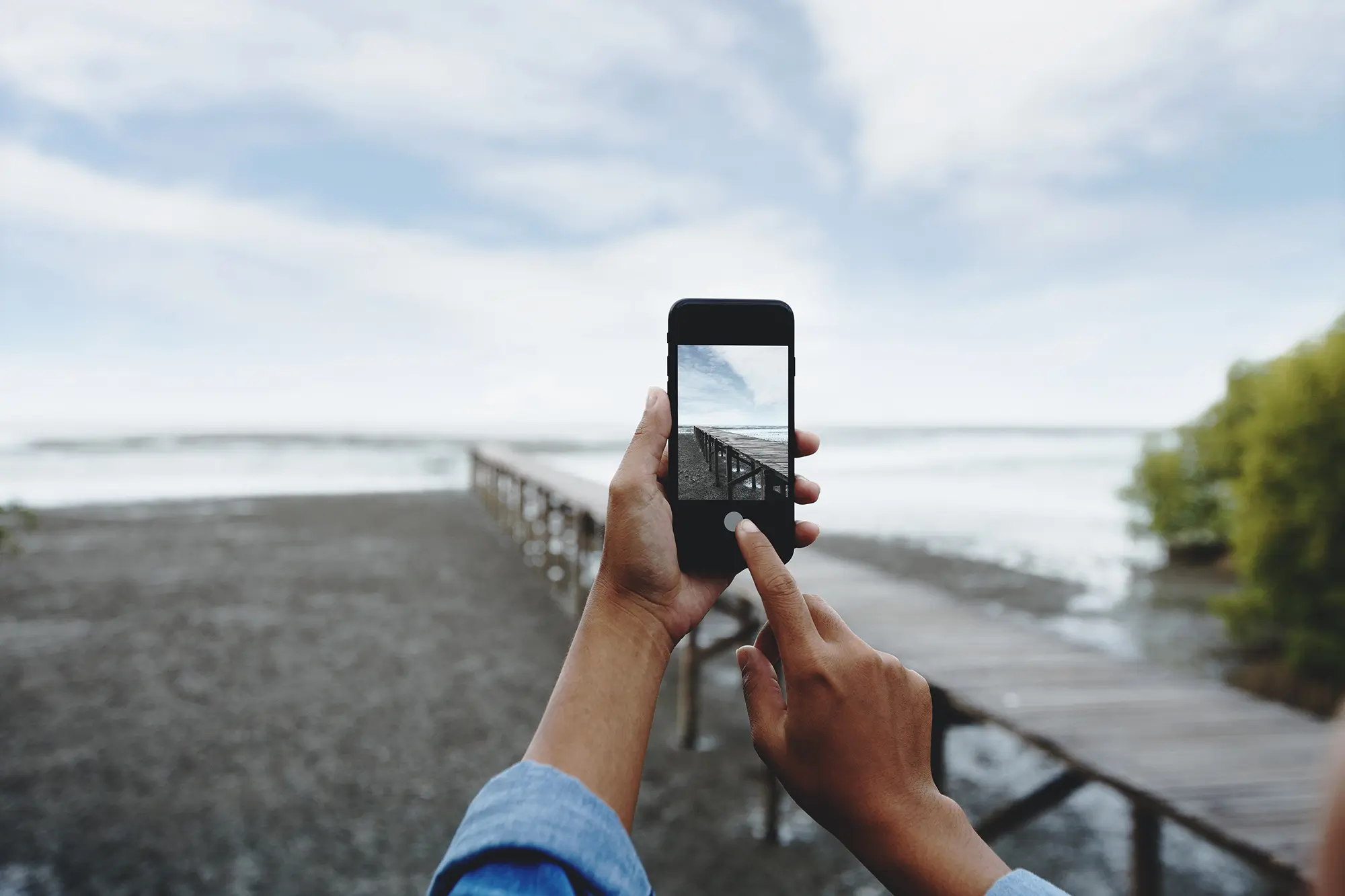 A person takes please a landscape photograph with an iPhone.